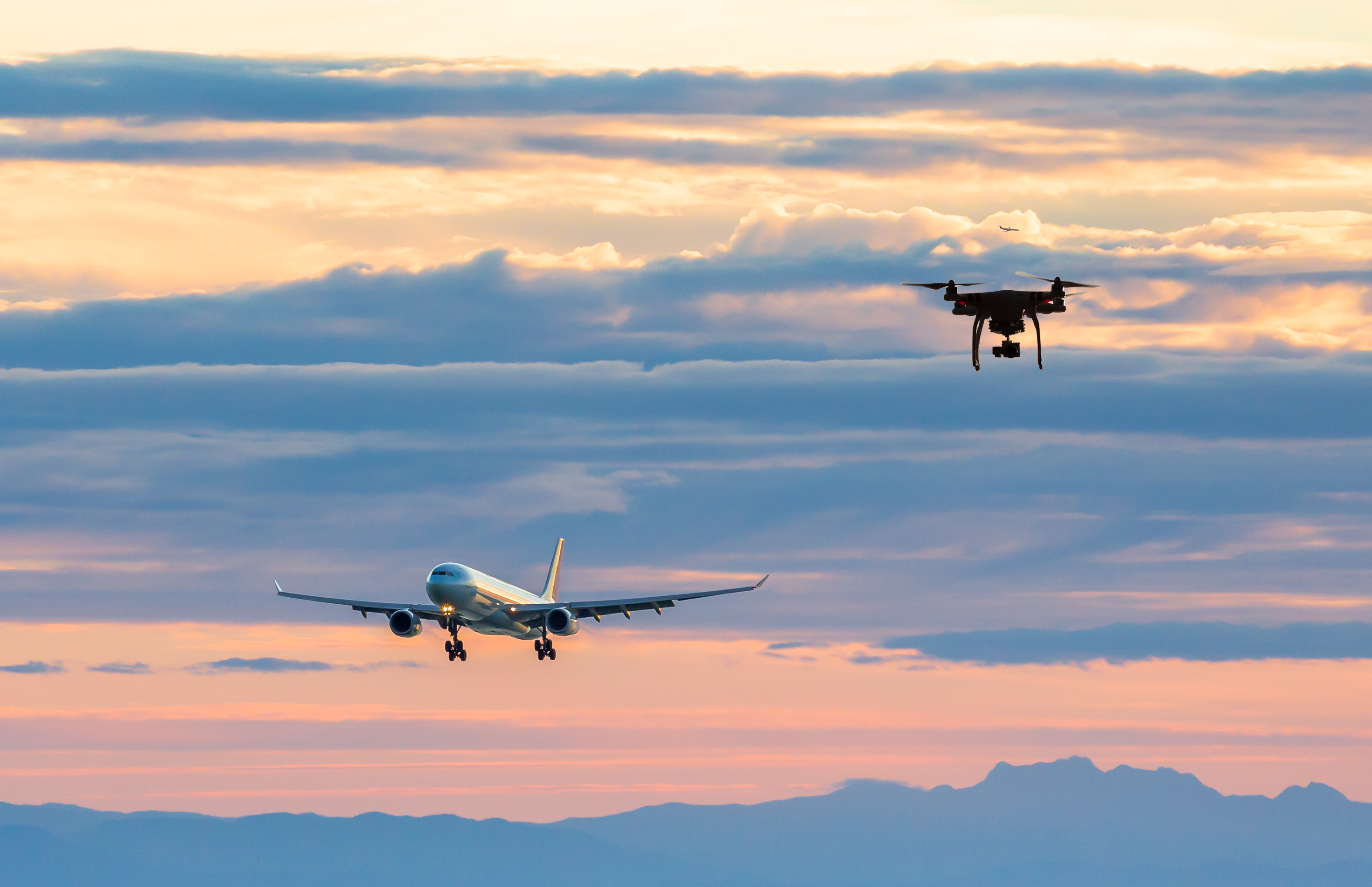 An animation of a aircraft on approach to an airport with a drone flying towards the aircraft