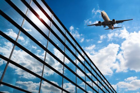 glass curtain wall and aircraft against a blue sky